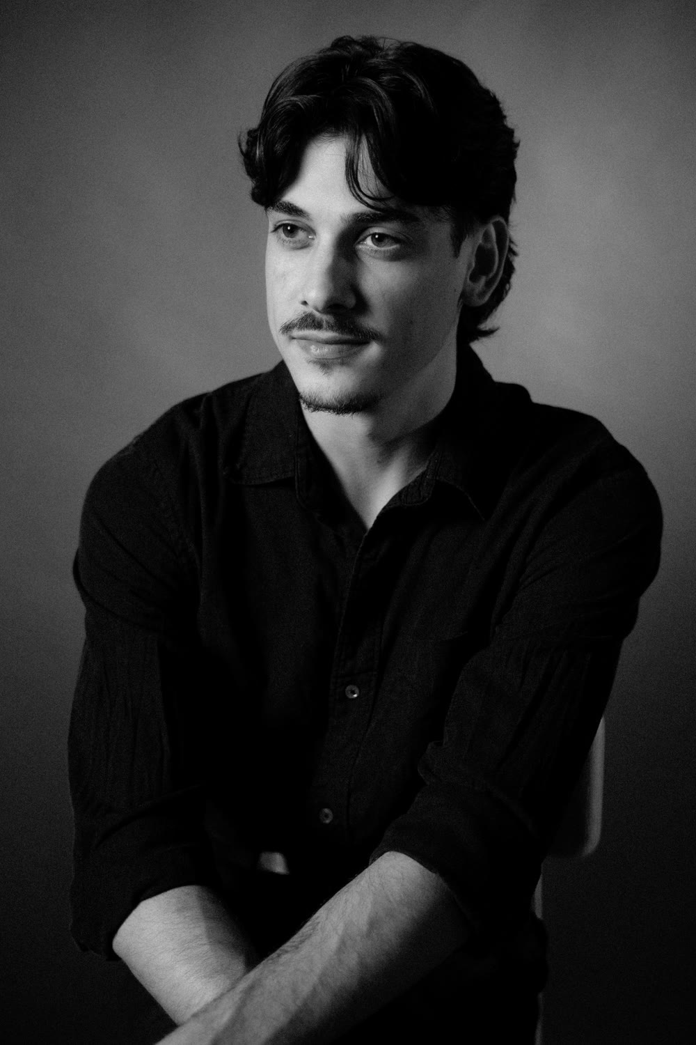 Michelangelo Corrado headshot — black shirt, looking off