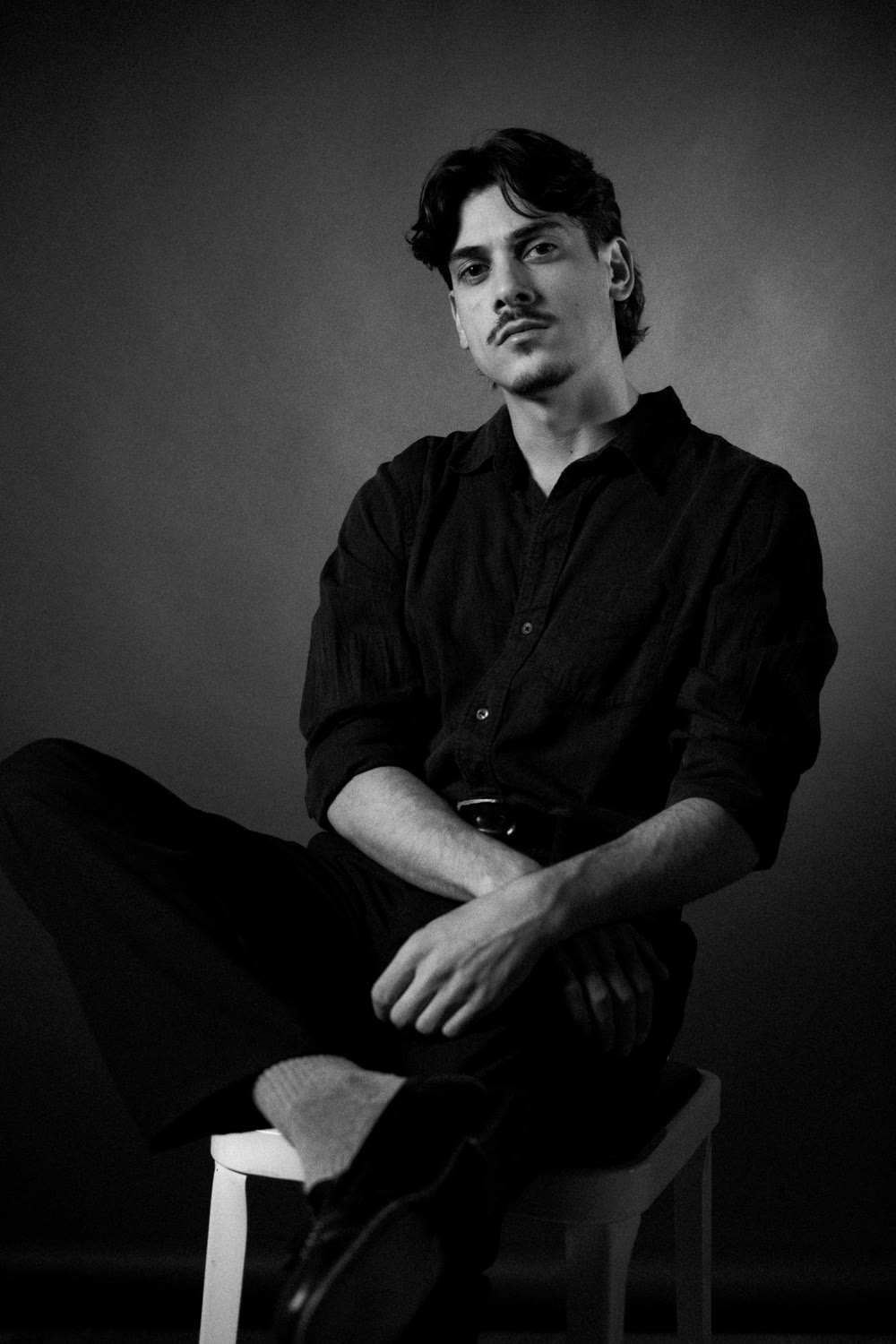Michelangelo Corrado headshot — black shirt, seated